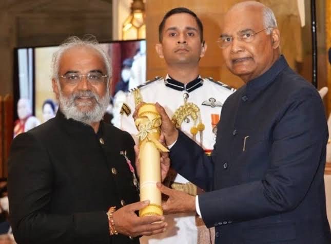 Close view of Savji Dholakia receiving the Padma Shri scroll from President Ram Nath Kovind.